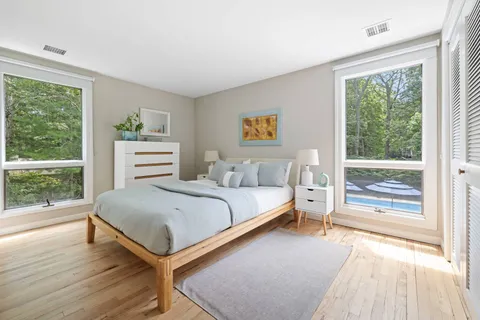 a bedroom with a bed and a large window