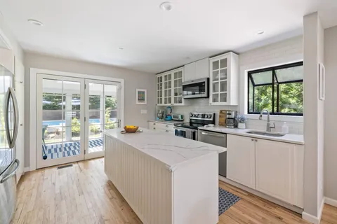 a kitchen with sink a stove and cabinets