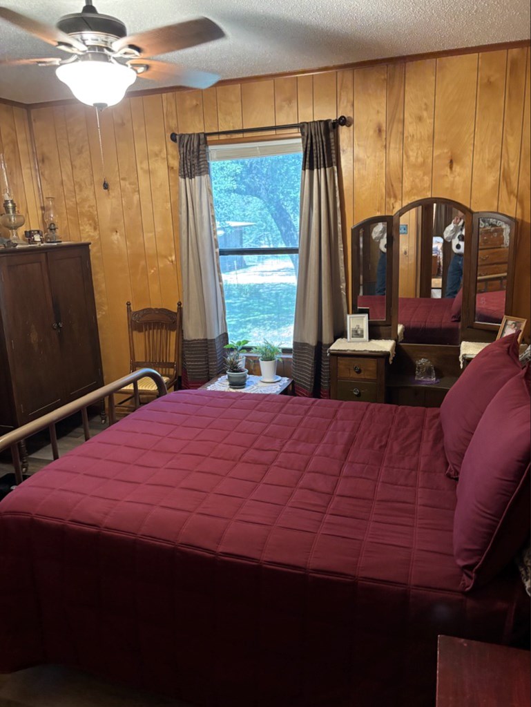 727 Cemetery Road Stonewall, TX 78671 - Photo 7 of 16 a bedroom with a bed a chandelier and a window