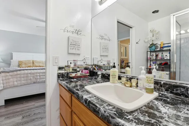 a bathroom with a granite countertop sink and a mirror