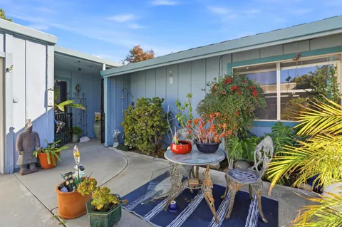 a front view of house with outdoor seating and flowers