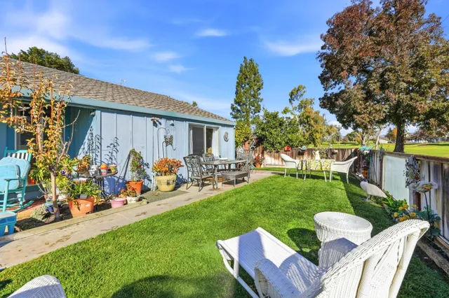 a view of a chair and table in backyard of the house