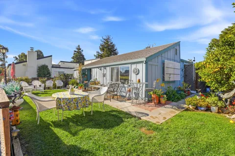 a front view of a house with garden and sitting area