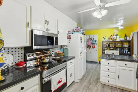a kitchen with stainless steel appliances a stove a microwave a refrigerator and cabinets