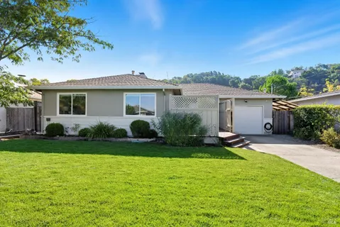 a view of a house with backyard sitting area and garden