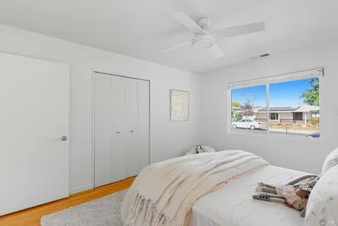 a bedroom with a bed and a baby fan