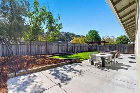 a view of a chairs and table in the back yard of the house