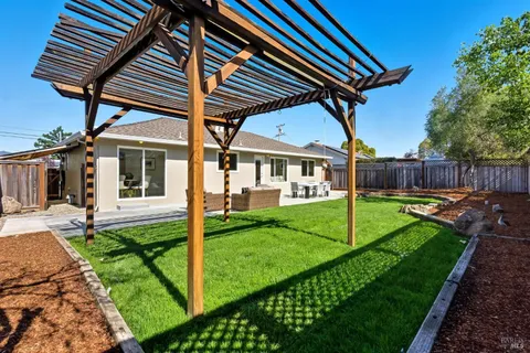 a view of a table and chairs in back yard of a house