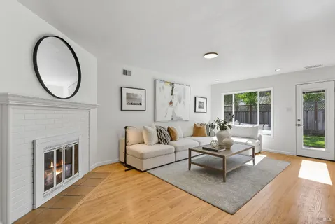 a living room with furniture a fireplace and a large window