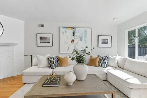 a living room with furniture and painting on the wall