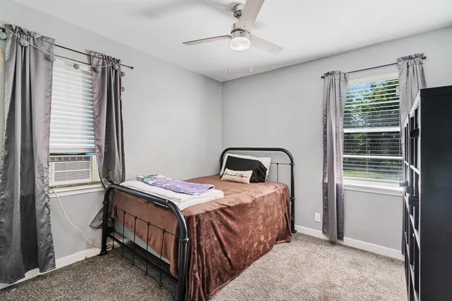 a bedroom with a bed next to a window