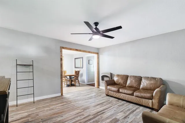 a living room with furniture and a wooden floor