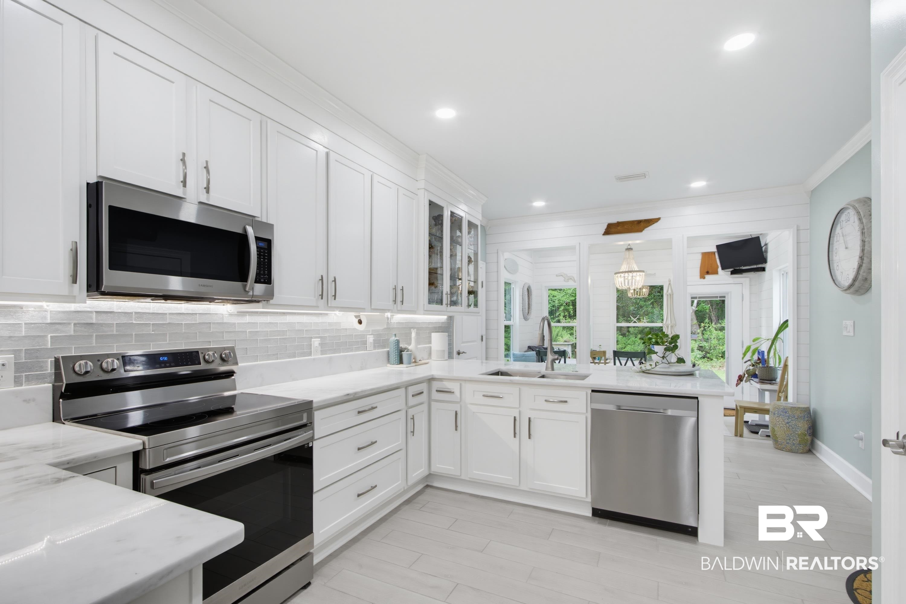 7472 Coopers Landing Road Foley, AL 36535 - Photo 6 of 40 Contemporary kitchen featuring white cabinetry, stainless steel appliances, light-toned tile wood-finish flooring, and a subway tile backsplash