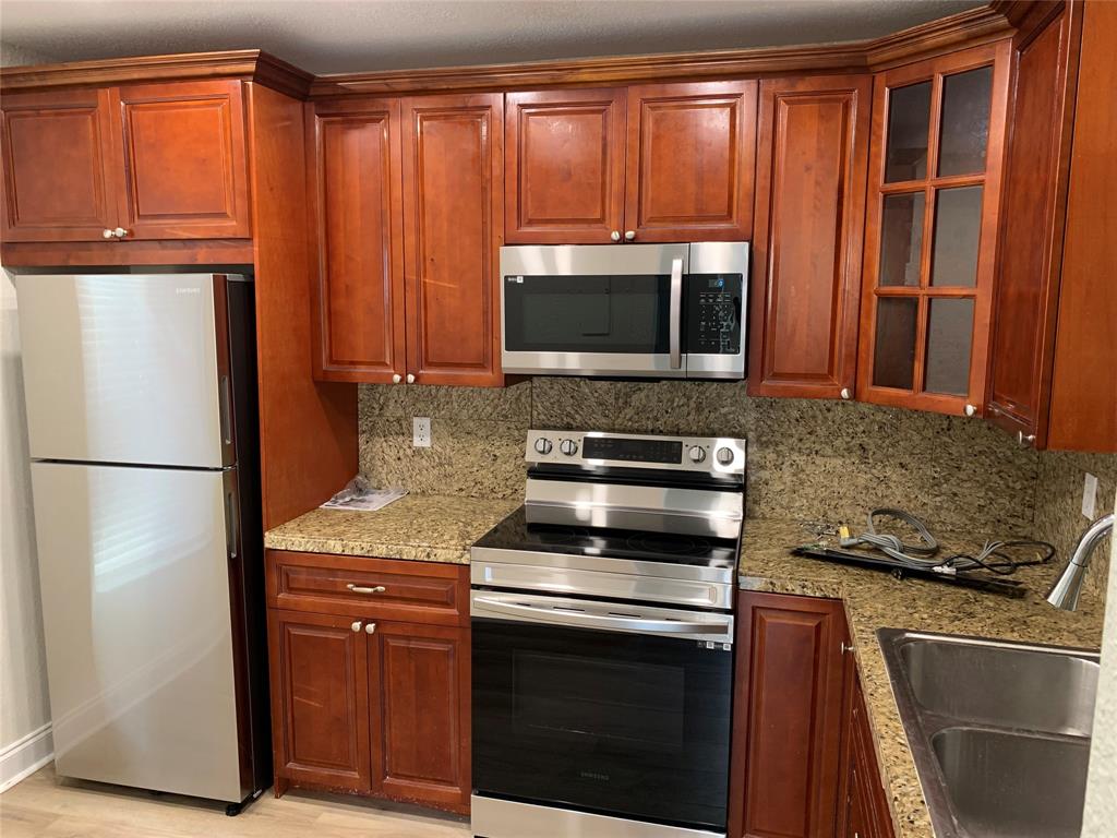 1700 Northwest 4th Avenue Boca Raton, FL 33432 - Photo 1 of 14 a kitchen with granite countertop a refrigerator stove and microwave