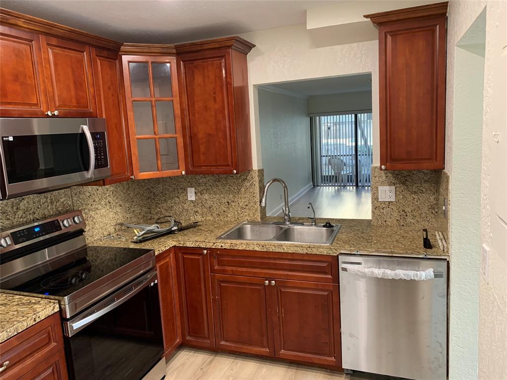 1700 Northwest 4th Avenue Boca Raton, FL 33432 - Photo 2 of 14 a kitchen with stainless steel appliances granite countertop a stove microwave and sink