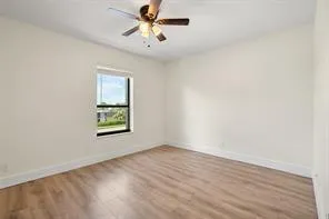 an empty room with a window and a fan