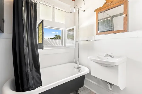a bathroom with a sink a bathtub and a window