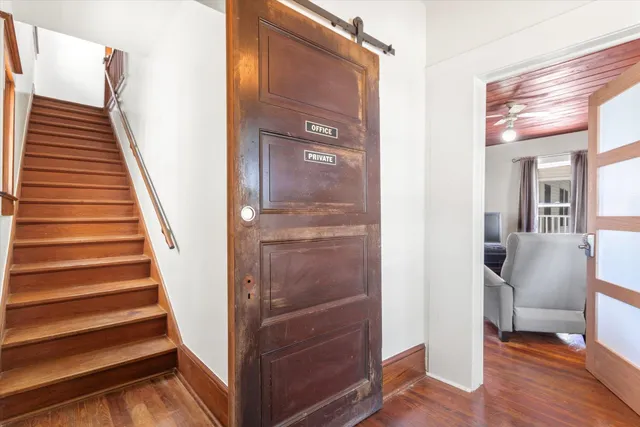 a view of a hallway with staircase and wooden floor