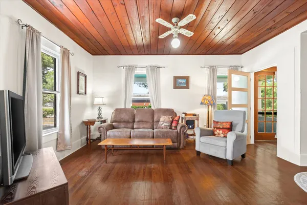 a living room with furniture white walls and a flat screen tv