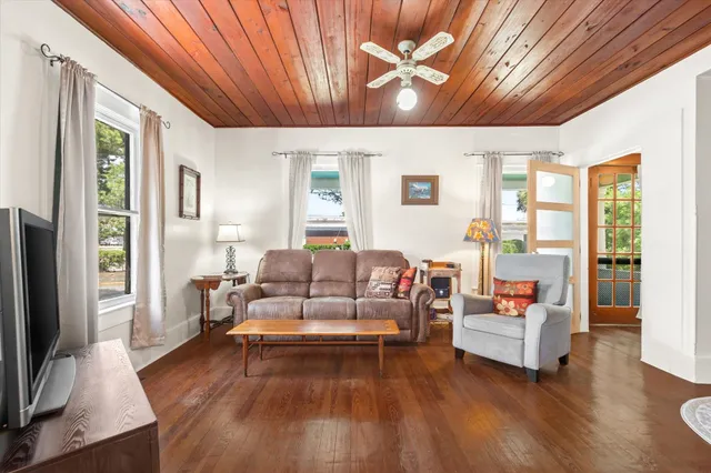 a living room with furniture white walls and a flat screen tv