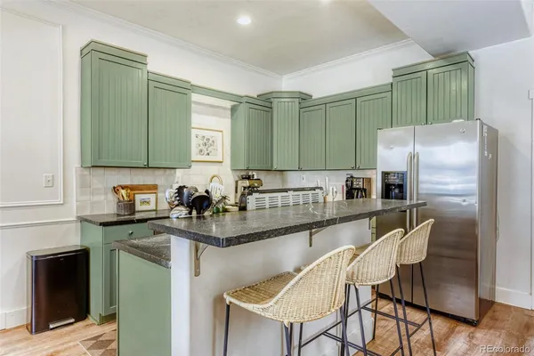 a kitchen with stainless steel appliances granite countertop a sink and a refrigerator