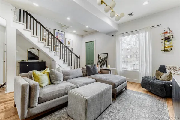 a living room with furniture and a wooden floor