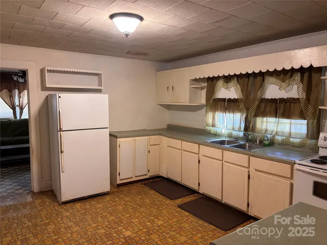 a kitchen with granite countertop white cabinets and white appliances