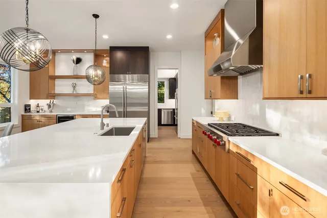 a large kitchen with stainless steel appliances granite countertop a stove a sink and a refrigerator