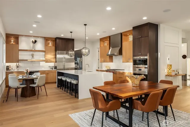a dining room with stainless steel appliances kitchen island granite countertop a dining table chairs and view kitchen