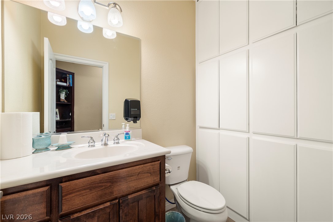 2181 Winery Road Pahrump, NV 89048 - Photo 34 of 52 1/2 bathroom in the Guest wing features ample built-in storage alongside a functional vanity and commode.