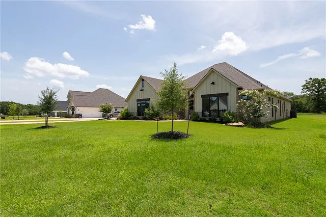 a view of a house with a swimming pool and a yard