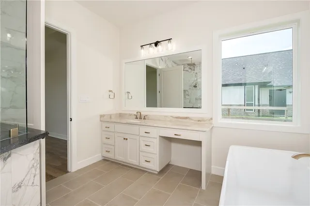 a spacious bathroom with a granite countertop sink mirror and a