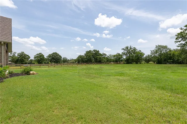 a view of a fountain in front of a house with a big yard
