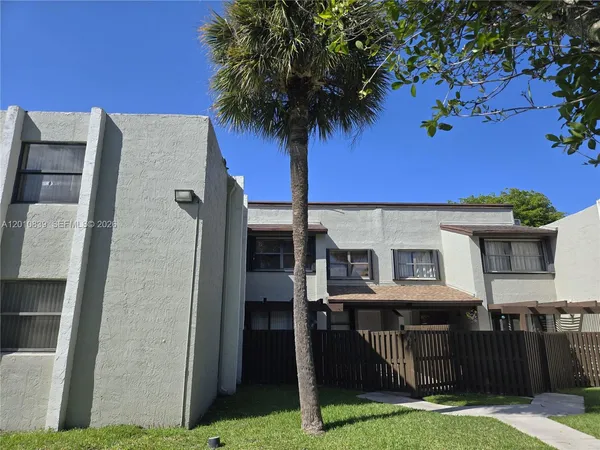 a view of a house with backyard and a tree