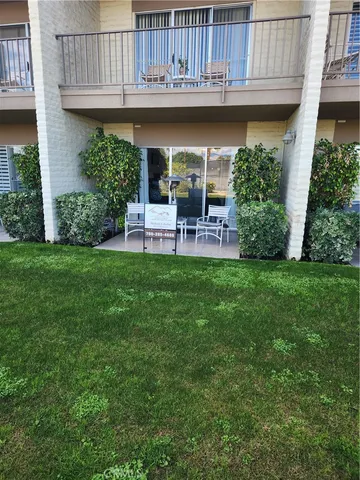 a view of a chair and table in backyard of the house