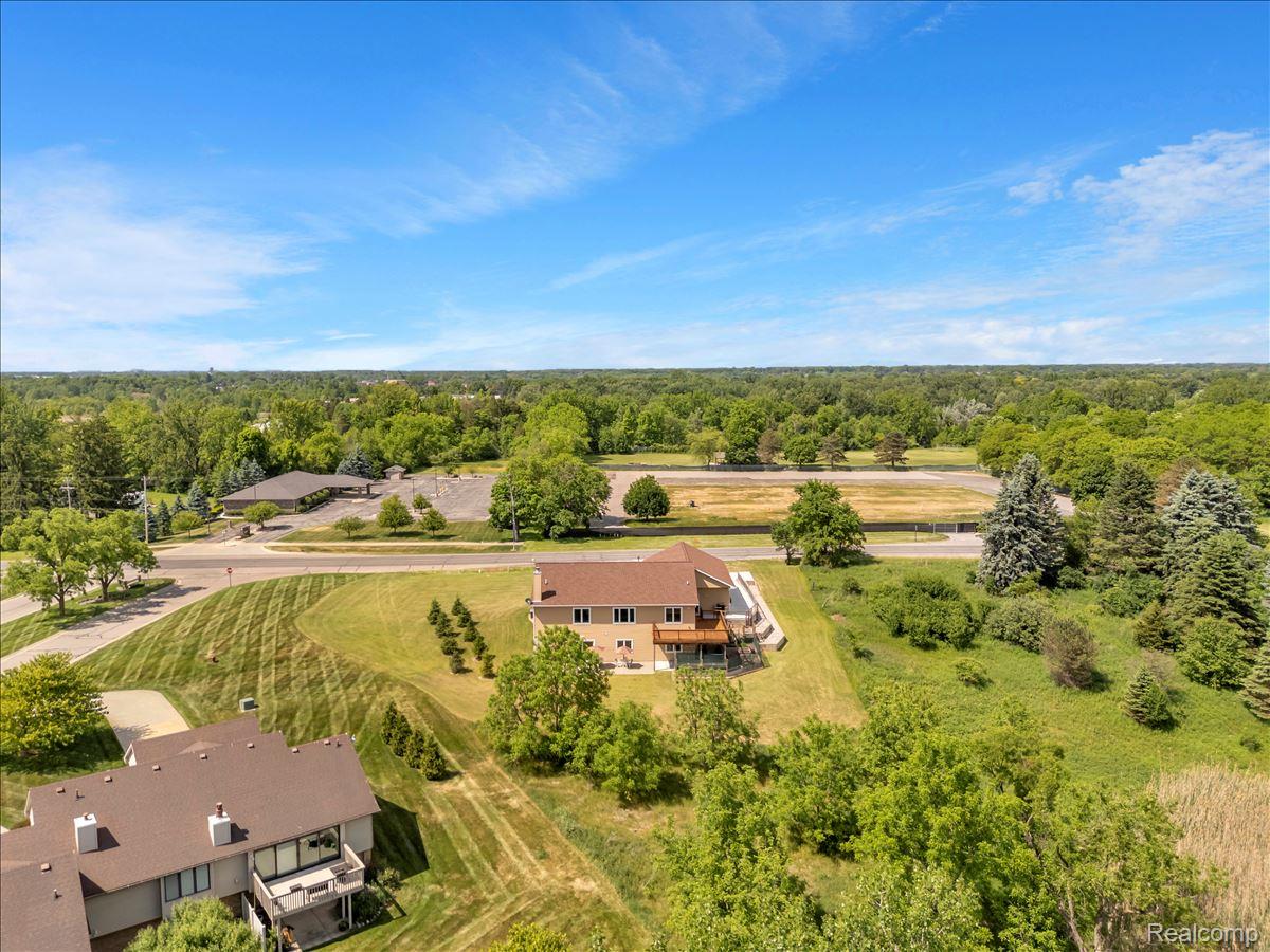 4266 McCandlish Road Grand Blanc, MI 48439 - Photo 64 of 68 Aerial perspective showcasing a property with a multi-level deck, surrounding green space, and mature trees