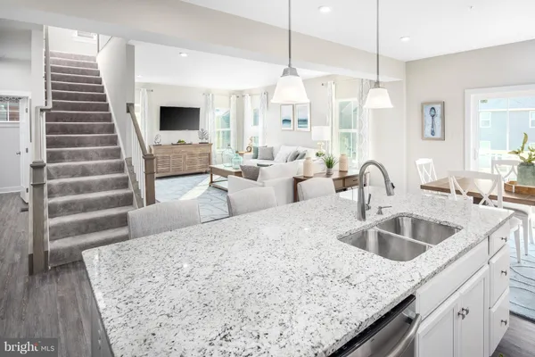 a kitchen with granite countertop a sink a counter and cabinets