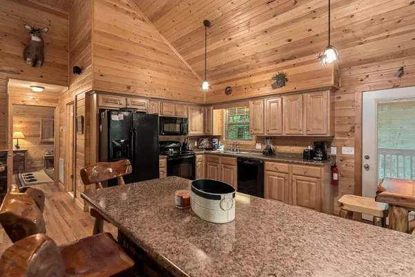 a kitchen with kitchen island granite countertop a refrigerator stove and sink