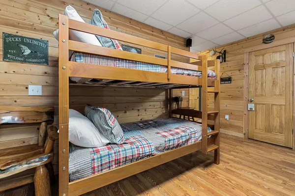 a bedroom with a bed and wooden floor