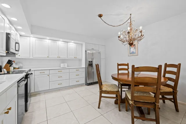 a kitchen that has a cabinets counter space dining table and stainless steel appliances