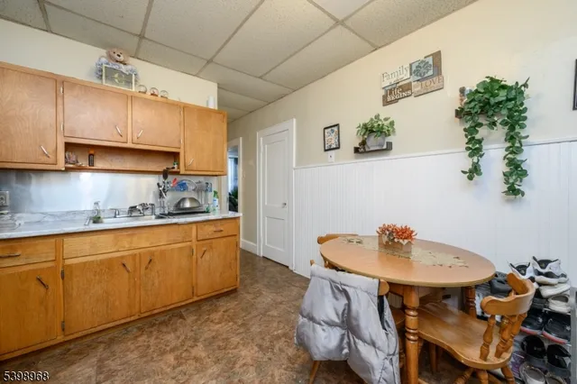 a kitchen with stainless steel appliances a sink a stove a dining table and chairs