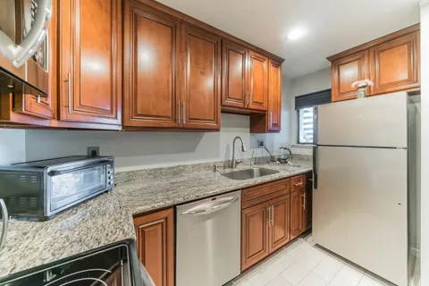 a kitchen with stainless steel appliances granite countertop a sink stove and refrigerator