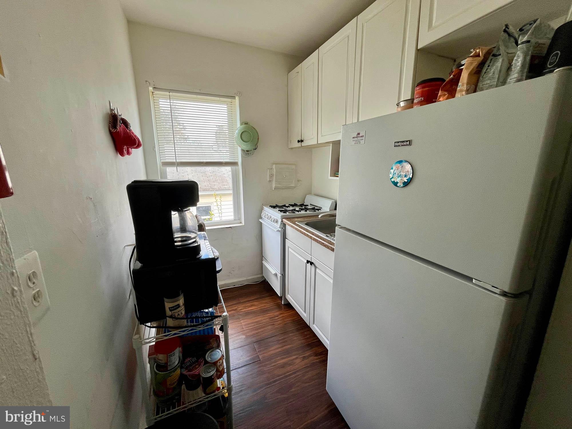 1725 Earhart Road Baltimore, MD 21221 - Photo 24 of 48 a kitchen with a refrigerator a stove top oven a counter space and wooden floor