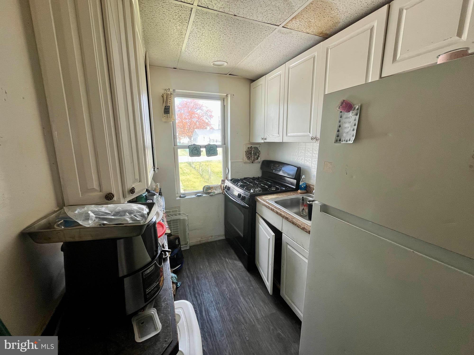1725 Earhart Road Baltimore, MD 21221 - Photo 28 of 48 a kitchen with a stove a sink and a refrigerator