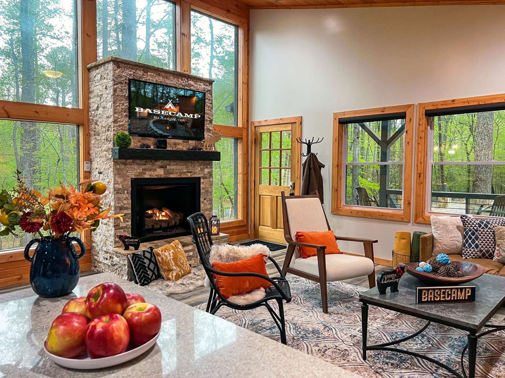 7 Addle Court Ellijay, GA 30540 - Photo 8 of 20 a living room with furniture a fireplace and floor to ceiling windows