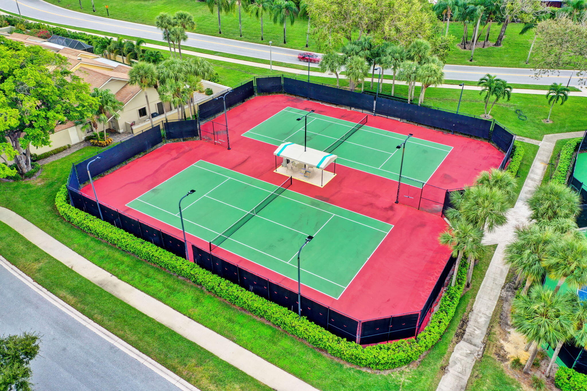 156 Ocean Pines Terrace Jupiter, FL 33477 - Photo 40 of 41 a view of a tennis ground with large trees
