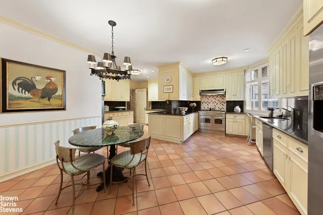 a view of a dining room with furniture a chandelier and kitchen view