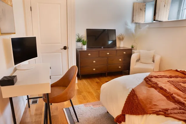 a bedroom with a bed and painting on the wall