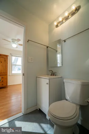 a white toilet sitting next to a bathroom sink and vanity