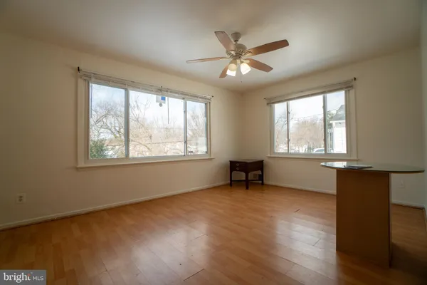 a view of an empty room with a window and wooden floor